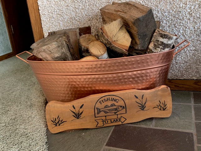 wooden fish sign in front of wood pile