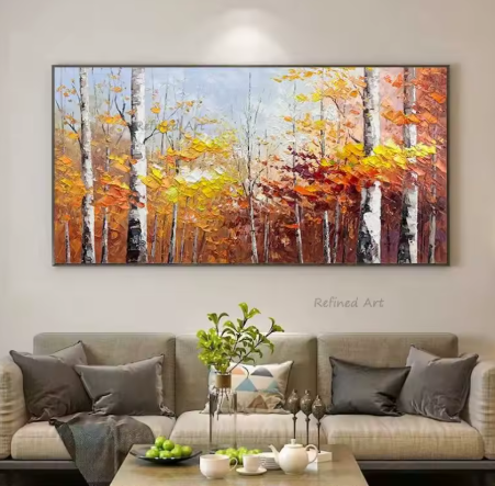Large abstract painting of autumn trees above a living room sofa with decorative items.