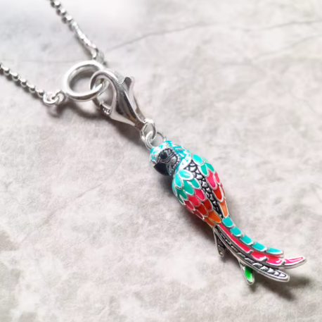Colorful parrot pendant on a chain against a light background