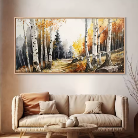 Painting of a forest scene with birch trees on a wall above a beige sofa.