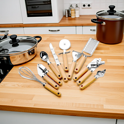 Set of kitchen utensils on a wooden countertop with pots and pans in the background.
