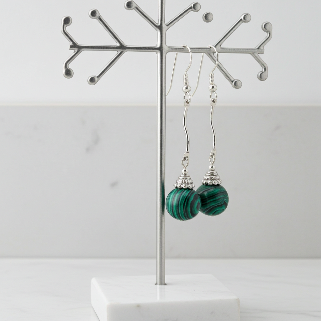 Green marbled earrings on a silver earring stand against a white background