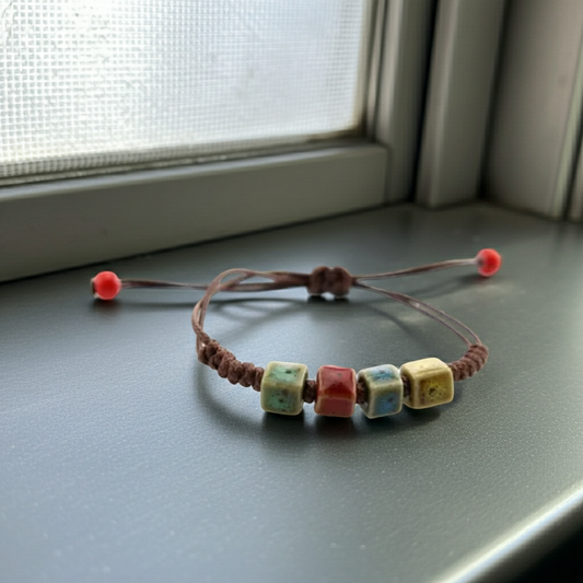 Bracelet with colorful beads on a flat surface near a window