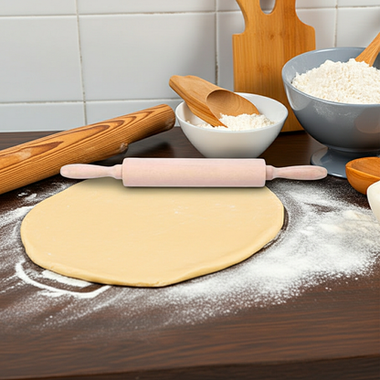 Baking setup with rolled-out dough, rolling pin, and kitchen utensils on a wooden surface.