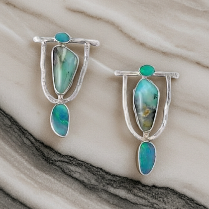 Pair of earrings with turquoise stones on a marble surface