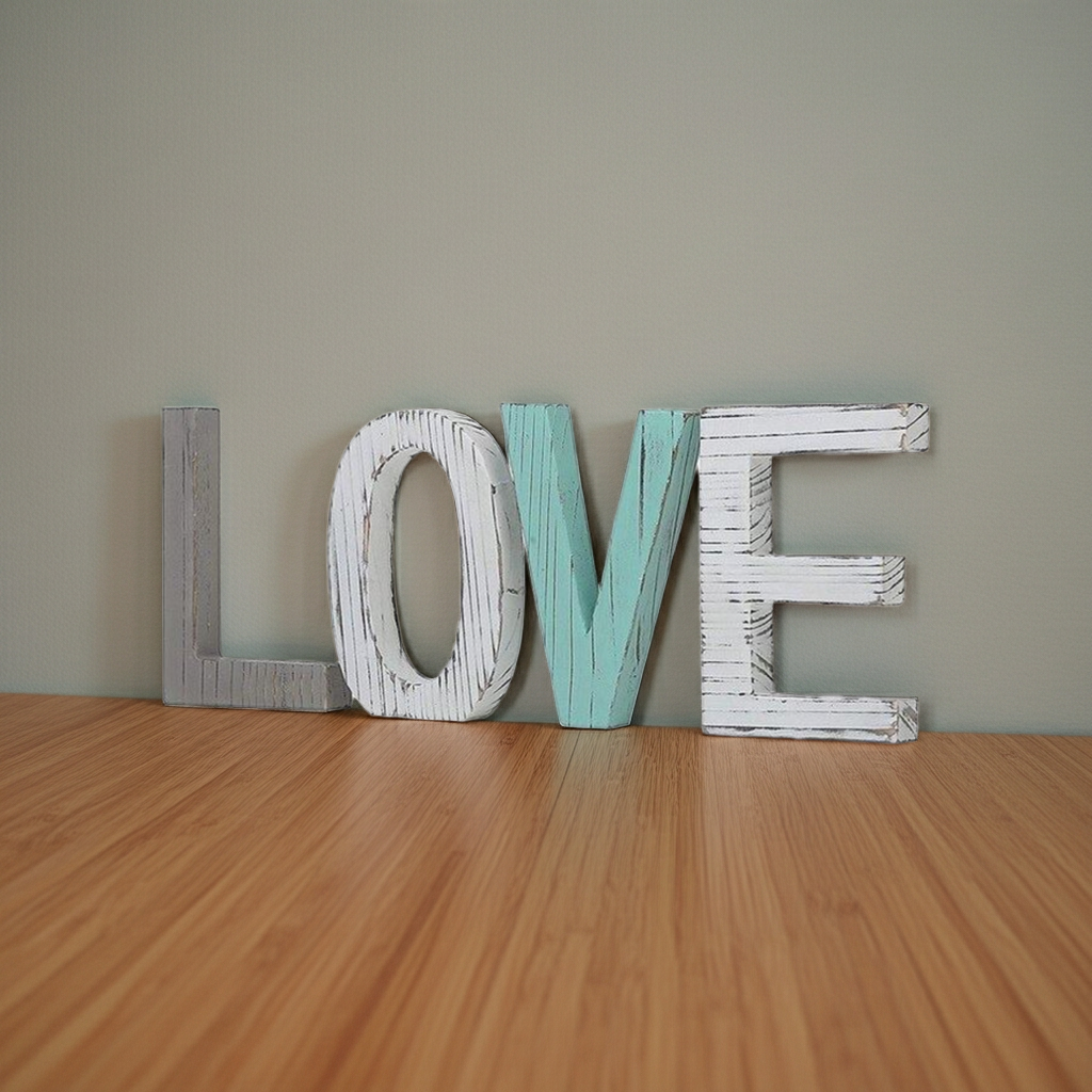 Wooden letters spelling 'LOVE' on a wooden floor with a plain wall background