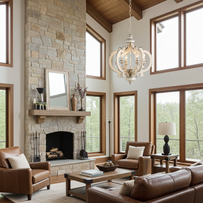 Distressed chandelier hanging in living room with stone fireplace, large windows, and brown furniture.