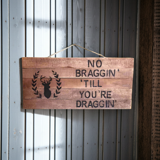 Wooden sign with text and deer silhouette on a metal wall