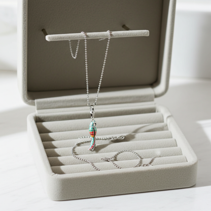 Necklace with a colorful pendant in an open jewelry box on a white surface