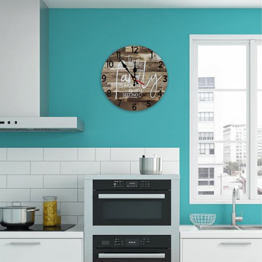 Wooden wall clock with decorative text on a teal wall in a kitchen.