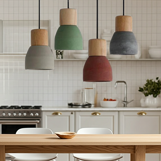 Colorful pendant lights hanging above a kitchen table with a tiled wall and kitchen appliances in the background.