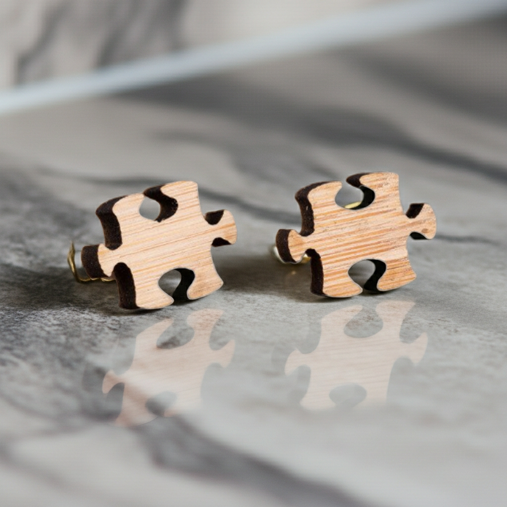 Wooden puzzle piece earrings on a reflective surface