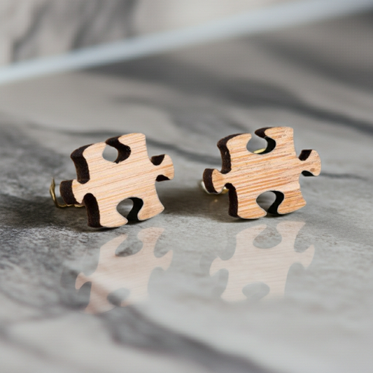Wooden puzzle piece earrings on a reflective surface