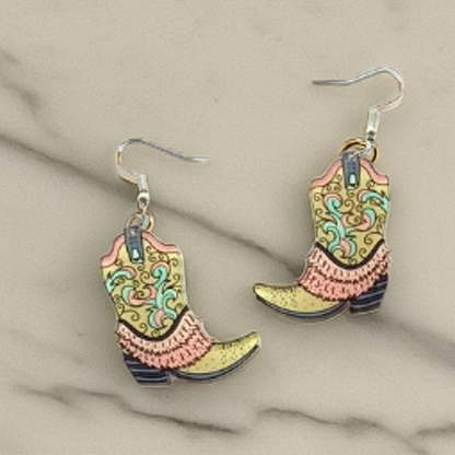 Cowboy boot earrings with colorful patterns on a beige fabric background