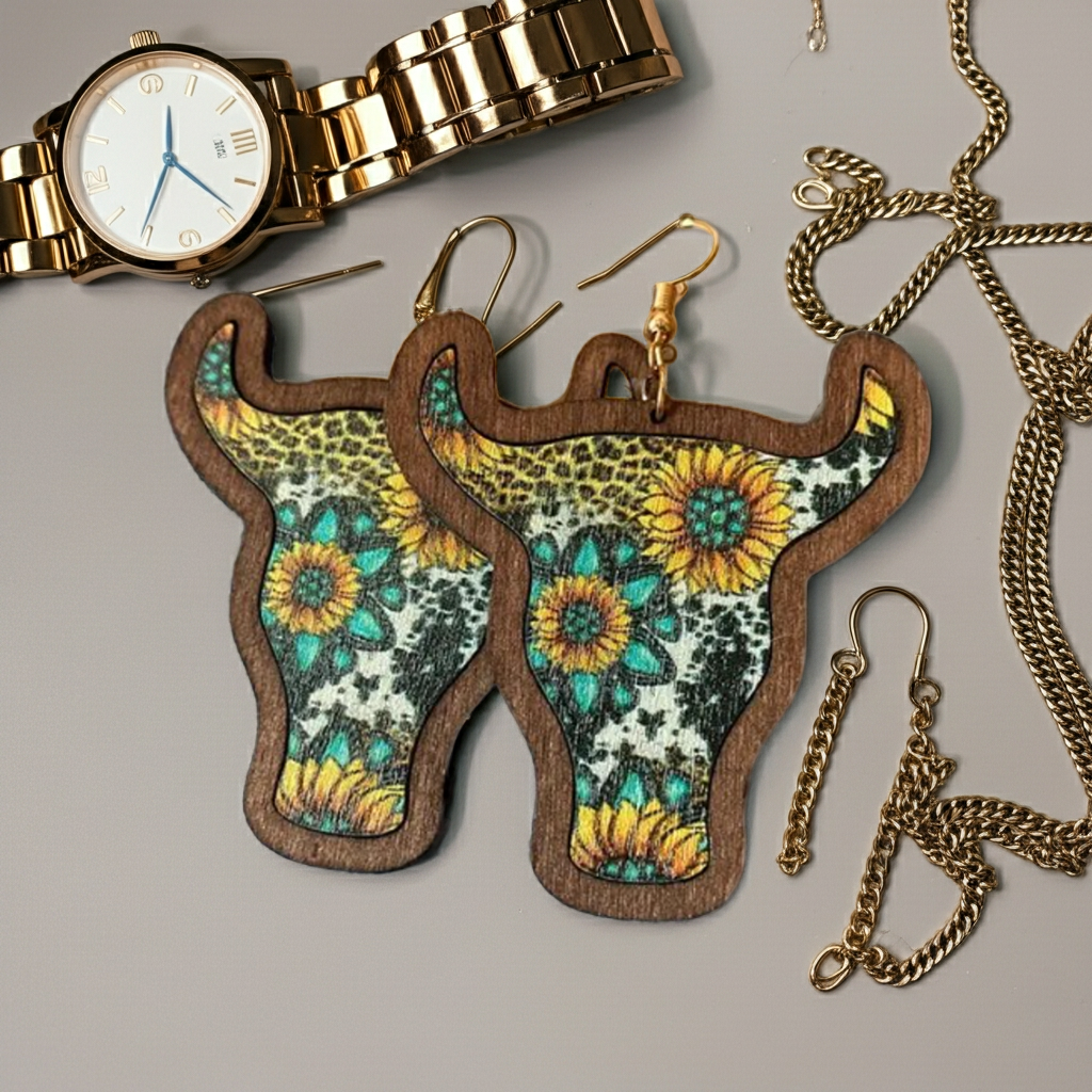 Floral-patterned cow head earrings with a gold watch and chain on a gray background