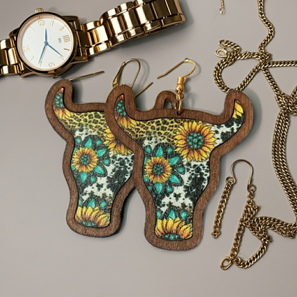 Floral-patterned cow head earrings with a gold watch and chain on a gray background