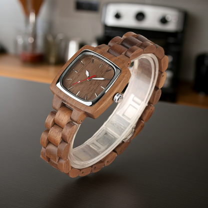 Wooden wristwatch on a dark surface with a blurred kitchen background