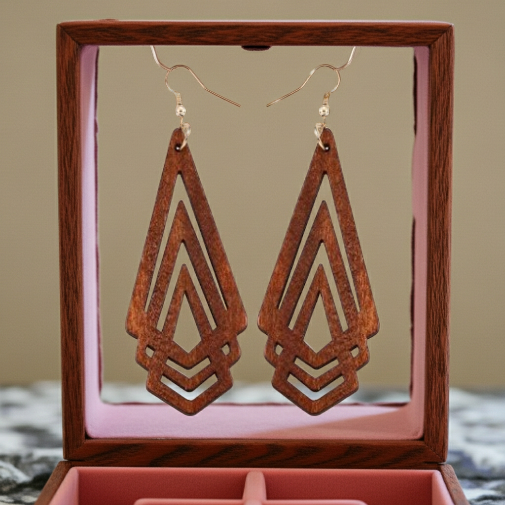 Wooden geometric earrings in a wooden display box with a pink interior.