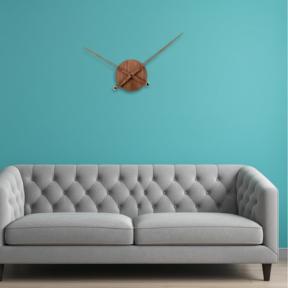 Gray tufted sofa against a teal wall with a wooden wall clock.