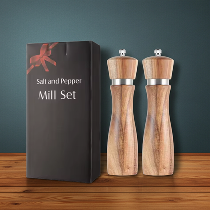 Wooden salt and pepper mill set with packaging on a wooden surface and dark background