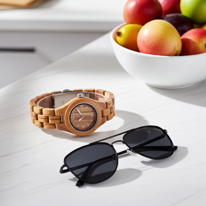 Wooden watch and sunglasses on a white surface with a bowl of fruit in the background