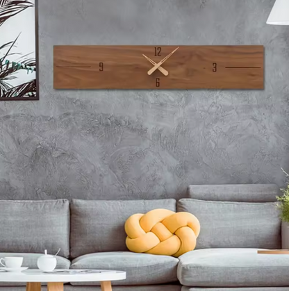 Wooden wall clock on a gray wall above a gray sofa with a yellow decorative pillow.