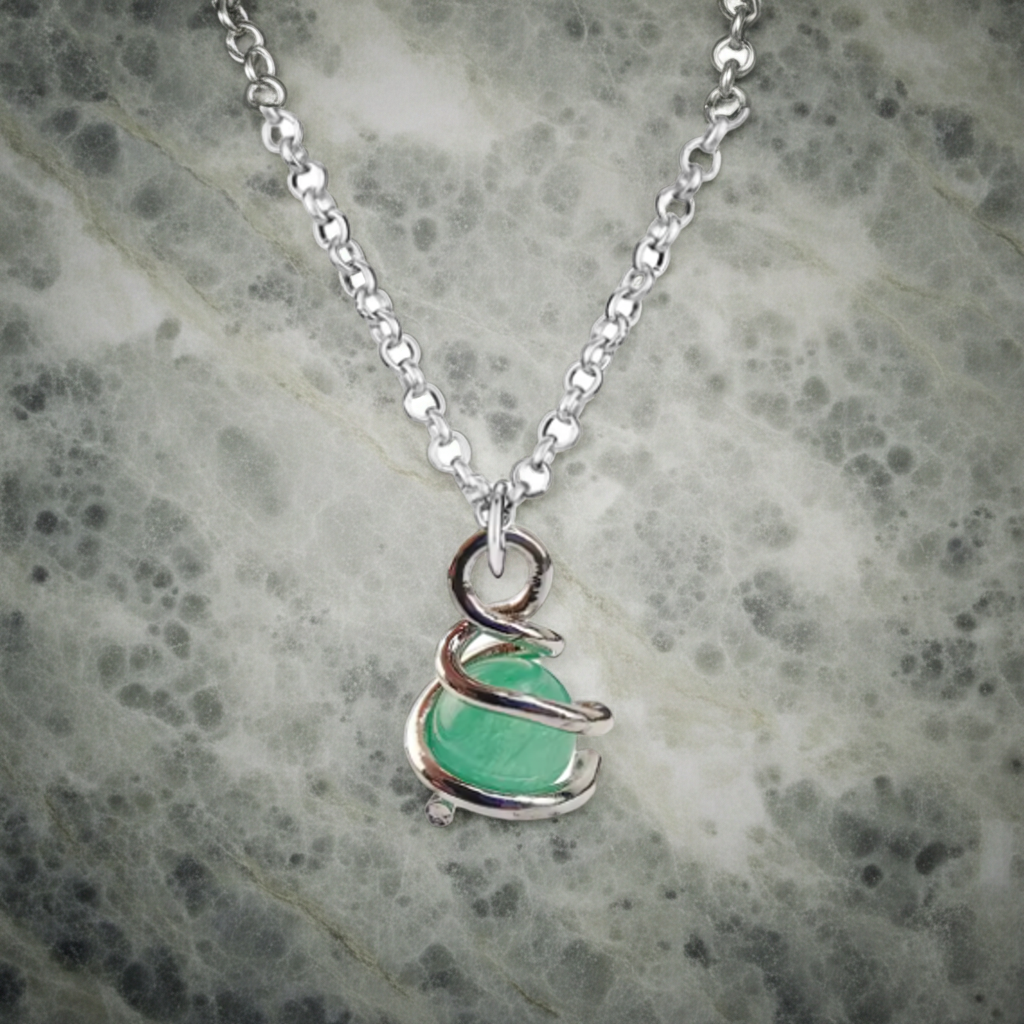Necklace with a green pendant on a textured gray background