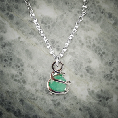 Necklace with a green pendant on a textured gray background