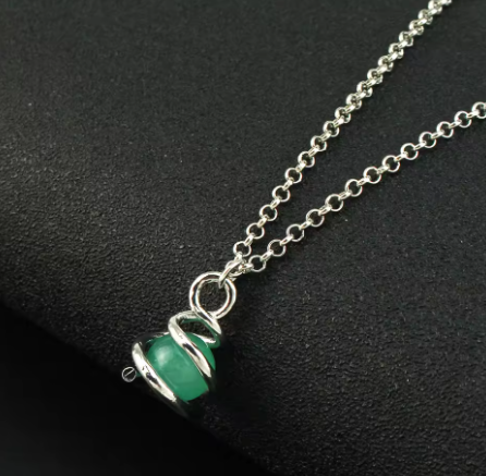 Necklace with a green pendant on a dark background