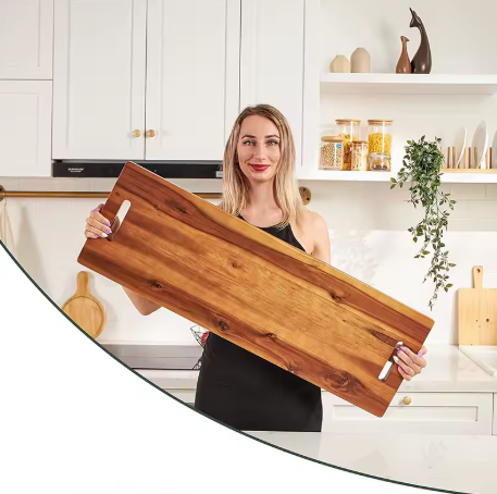 Woman holding a wooden cutting board in a kitchen