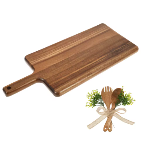 Wooden cutting board with a set of wooden utensils and greenery on a white background