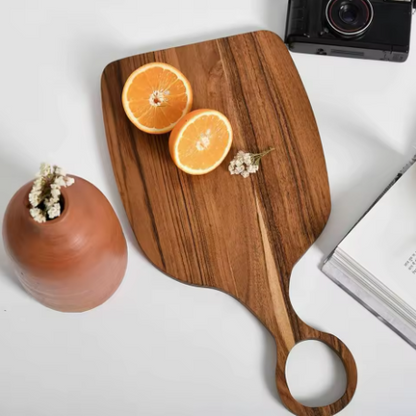Wooden cutting board with sliced oranges on a white surface