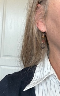 Person wearing earrings with a neutral background