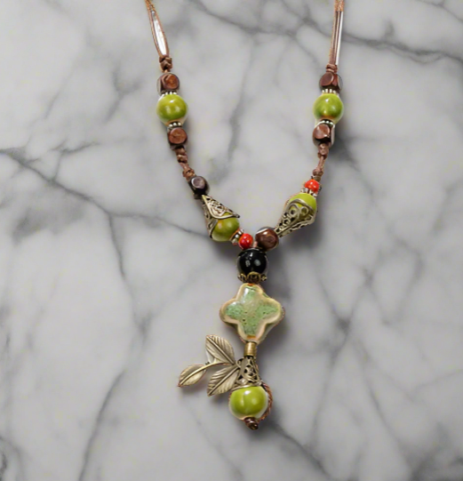 Necklace with green and brown beads on a marble background