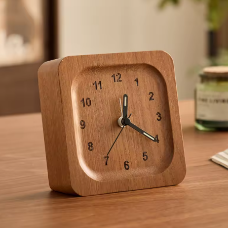 Wooden clock on a wooden surface with a blurred background
