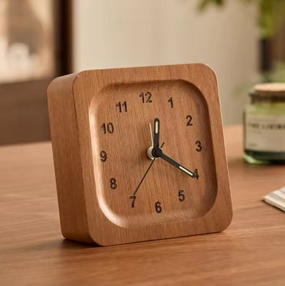 Wooden clock on a wooden surface with a blurred background
