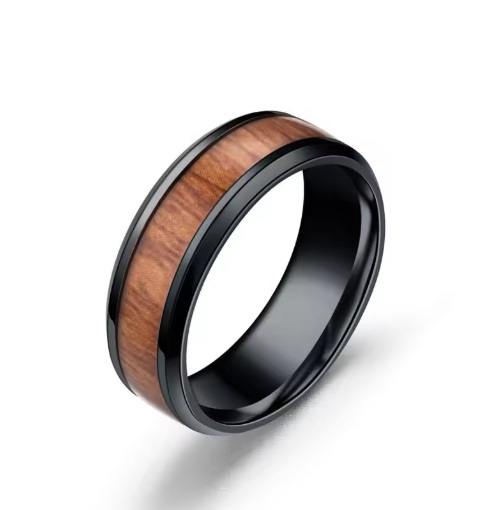 A black metal ring band featuring a polished brown wood grain inlay, shown on a clean white background.