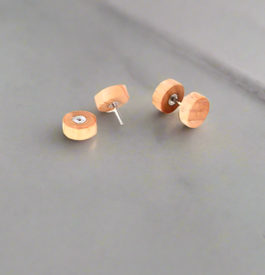 Wooden stud earrings on a gray surface