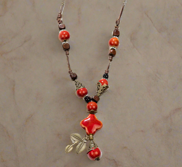 Necklace with orange and brown beads on a beige background