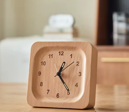 Wooden clock on a table with a blurred background