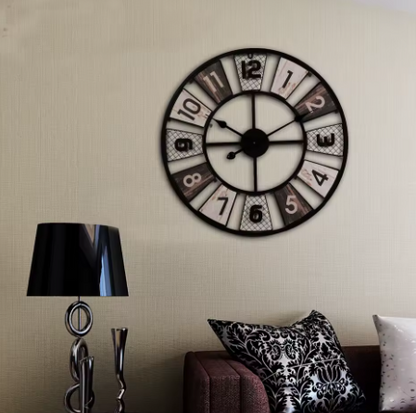 Decorative wall clock on a wall with a lamp and sofa in the foreground
