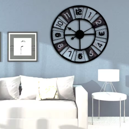 Large decorative wall clock on a light blue wall above a white sofa.
