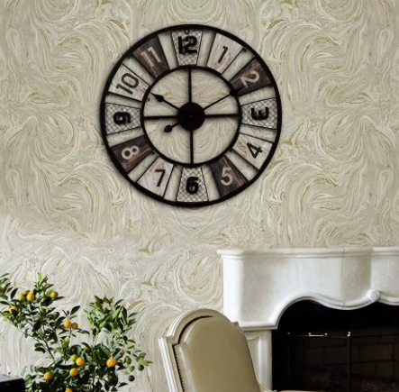 Decorative wall clock on a textured wall with a fireplace and plant in the foreground
