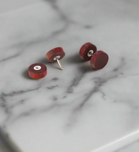 walnut stud earrings on a marble surface