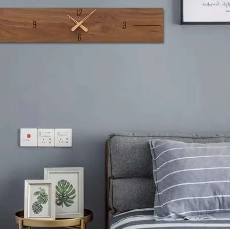 Wooden wall clock on a gray wall above a sofa with decorative items.