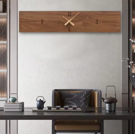 Wooden wall clock on a white wall above a wooden desk with decor items.
