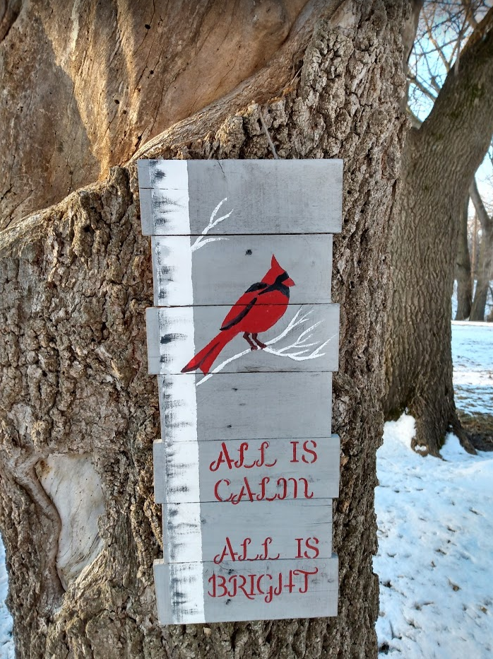 all is calm pallet sign hanging on tree