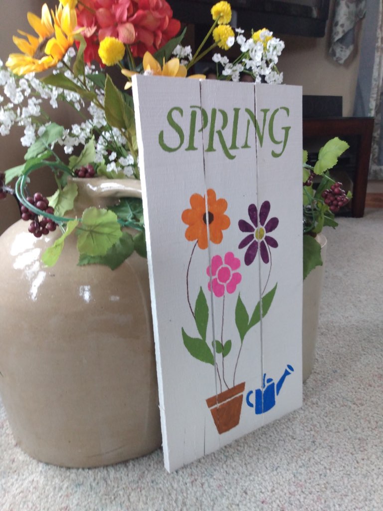 Spring-side view of pallet sign on floor in front of jug
