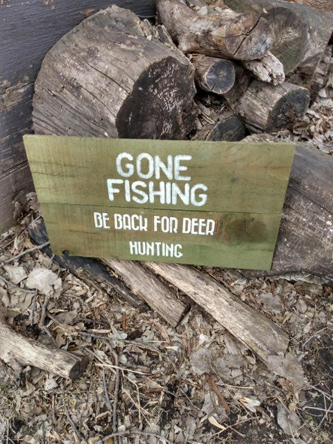 Gone Fishing sign siting on branch