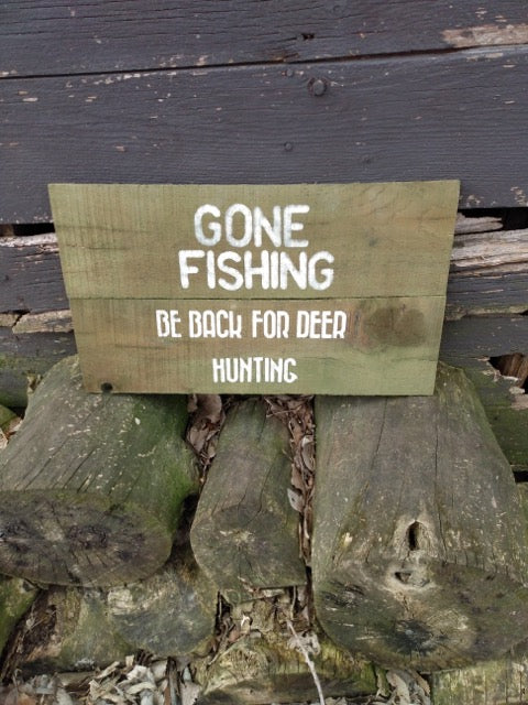 Gone fishing sign sitting on wood pile